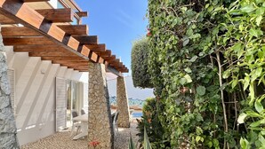 A stone pillar, a wooden pergola, and a tiled patio area with plants. - new holiday house with pool and exclusive furniture (Sagres)