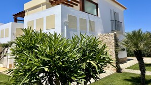 A modern two-story house with a white facade, large windows, and a wooden pergola. - new holiday house with pool and exclusive furniture (Sagres)