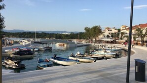 A marina with various boats docked, a pedestrian walkway, and buildings in the background. - modern Apartment, only a few minutes to the beach and the city centre (Kvarner Bucht)