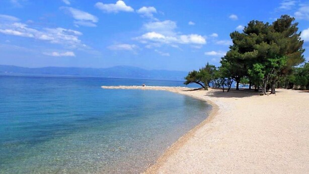 A beach with clear water, a sandy shore, and trees. - modern Apartment, only a few minutes to the beach and the city centre (Kvarner Bucht)