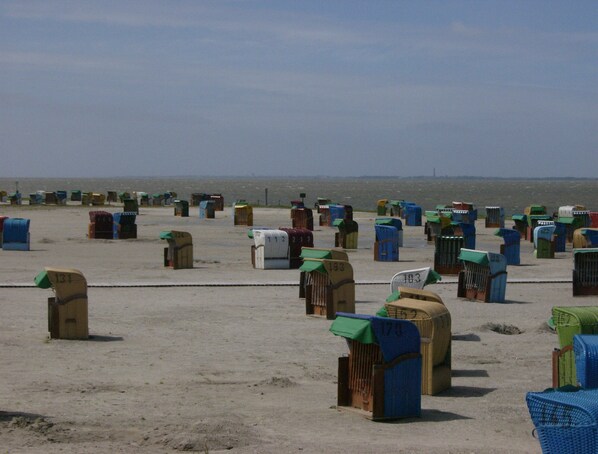 Een strand met talloze kleurrijke brievenbussen.