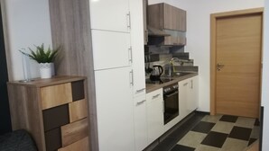 A kitchen with white cabinets, a wooden countertop, a sink, a kettle, and a potted plant. - Apartment Auer family  (Tulfes)