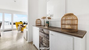 Una cocina moderna con un amplio ventanal, un sillón amarillo y un mueble de madera.
