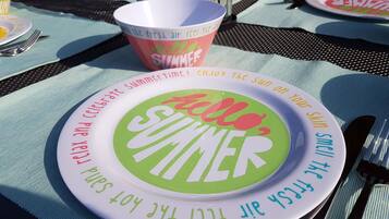 Una mesa con un plato que dice 'Hola Verano' y una taza con la inscripción 'Todo el Verano'.