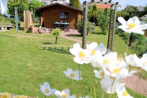 A wooden cabin with a patio, a small garden, and a wooden pergola. - Modern, bright apartment in Waldeck - Höringhausen (Höringhausen)