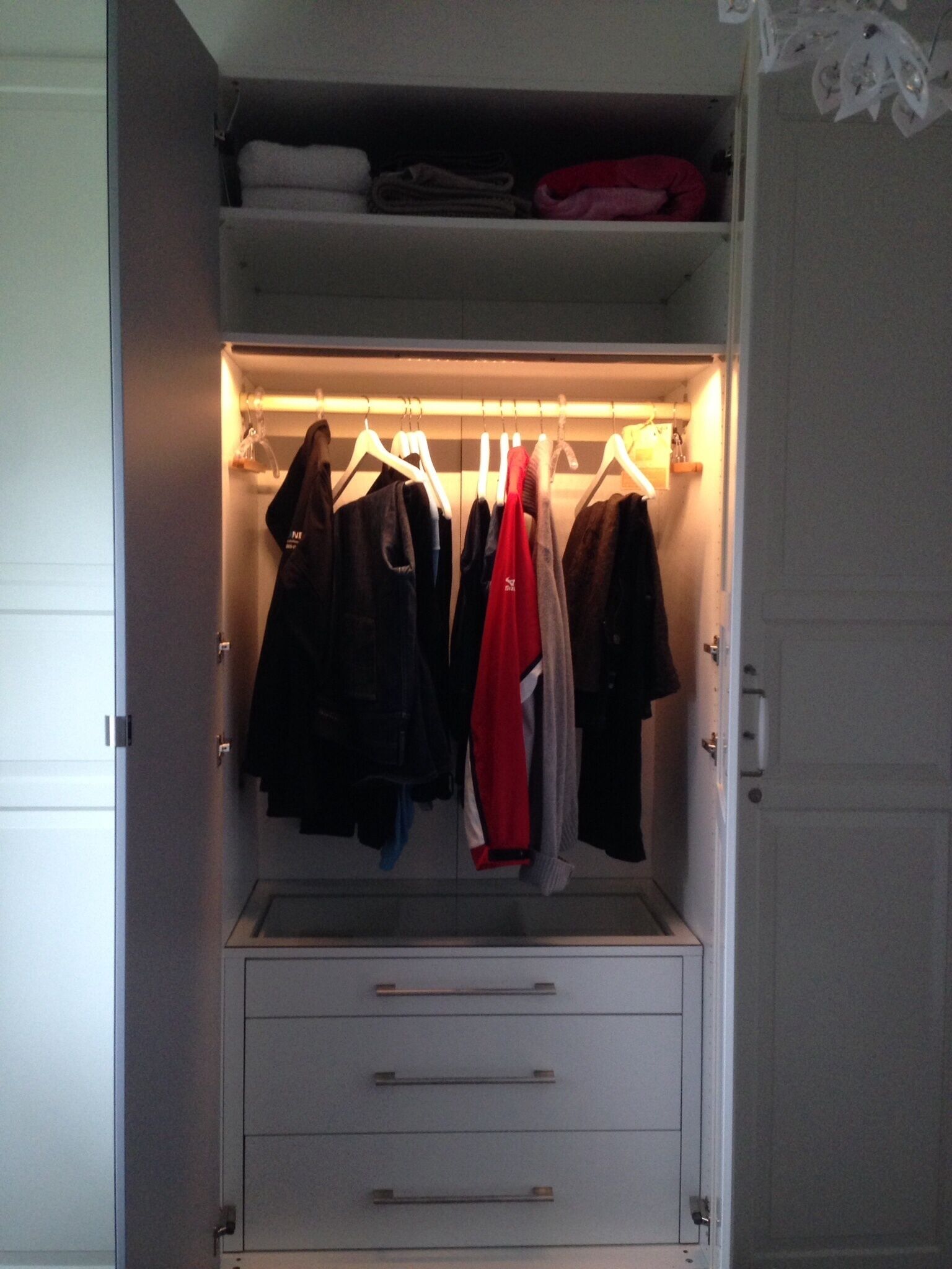 Un vestidor con espacio para colgar ropa y cajones.