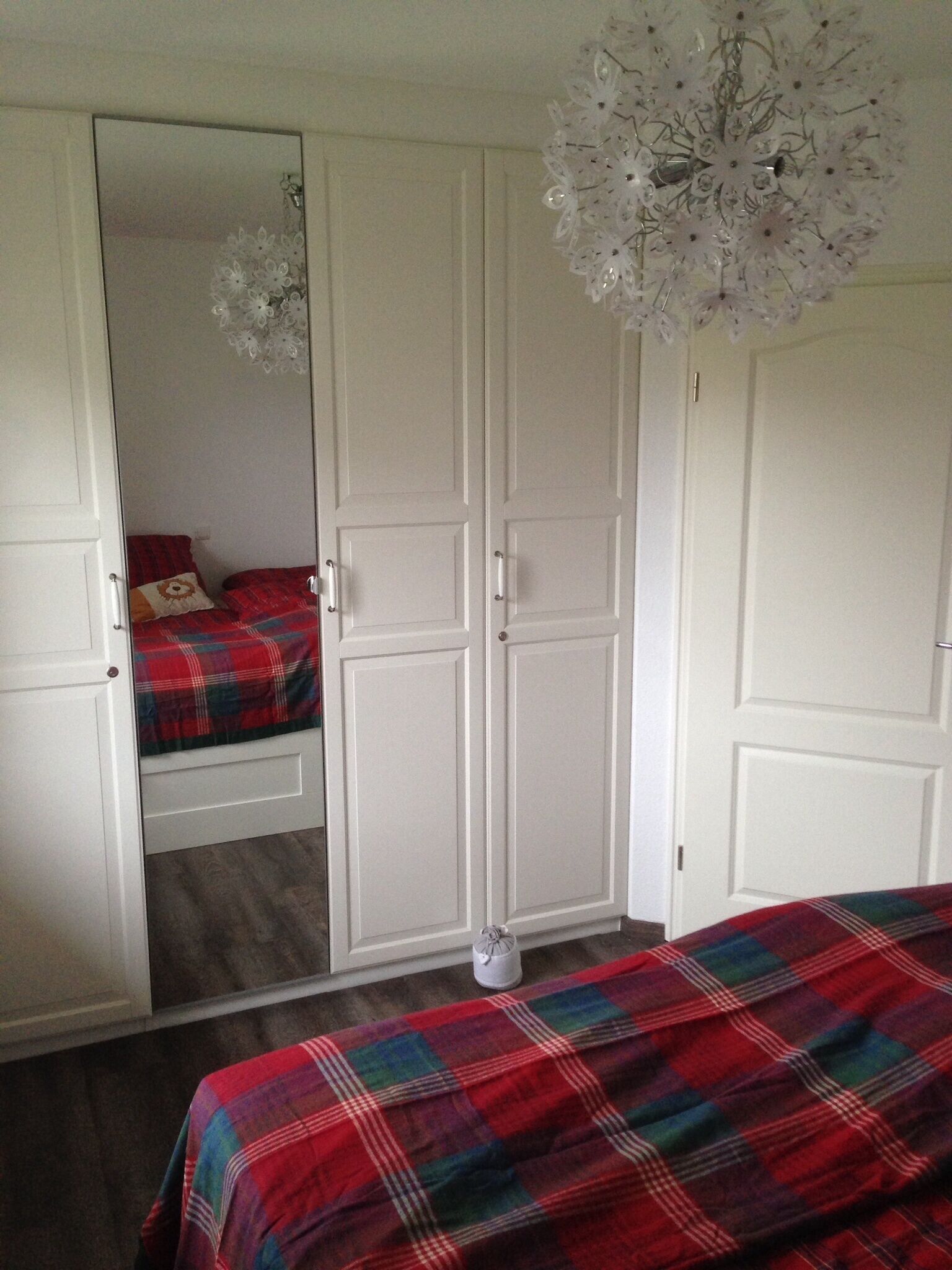 Une chambre à coucher avec un lit, une armoire et un miroir.