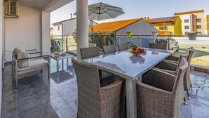 A dining area with a table, chairs, and an umbrella.