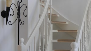 A white staircase with a black metal handrail and a wall-mounted light fixture. - BEAUTIFULLY FURNISHED HOLIDAY HOUSE FOR 4 PEOPLE WITH SEPERATE SAUNA HOUSE (Zingst)