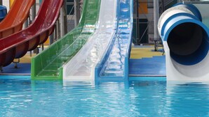 Ein Wasserpark mit mehreren Rutschen über einem Pool.