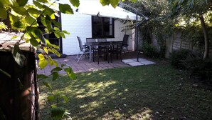 A small white house with a patio and a table with chairs.