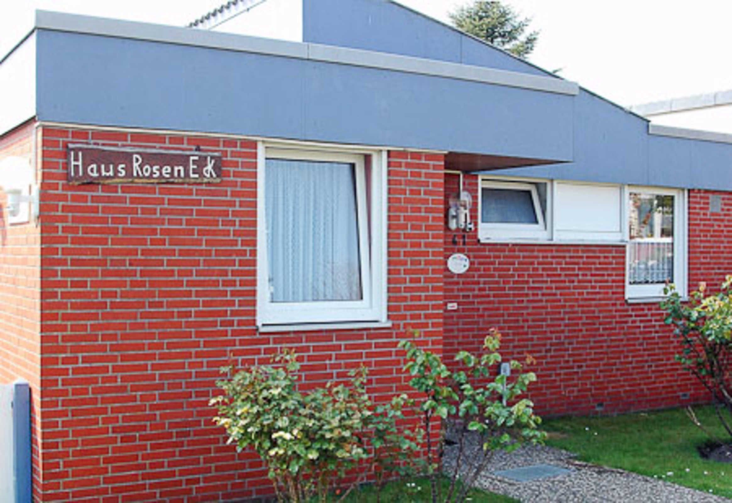 A red brick building with a sign reading "Haus RosenEck".
