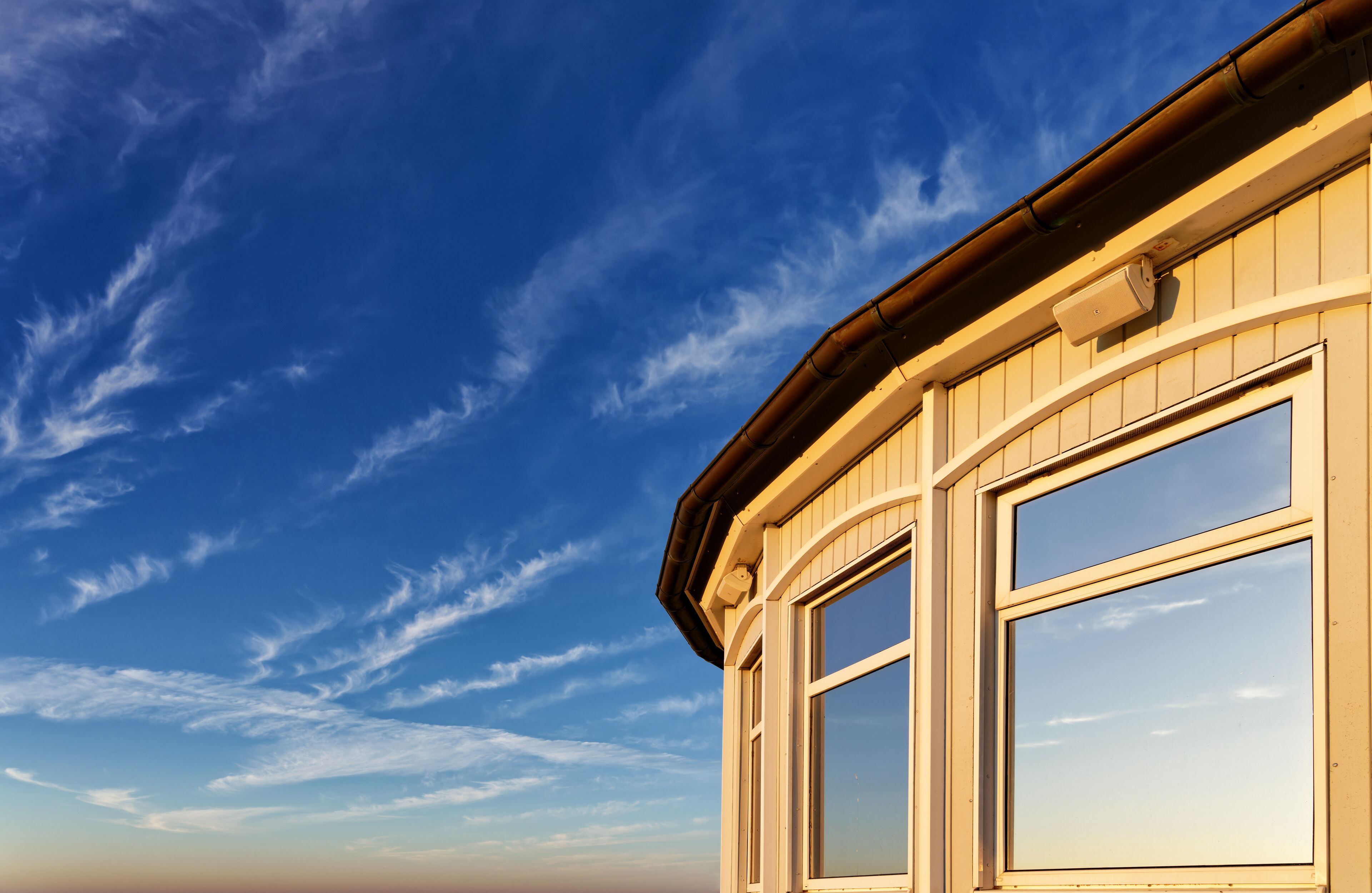 A building with a curved roof and a window with a clear view of the sky.