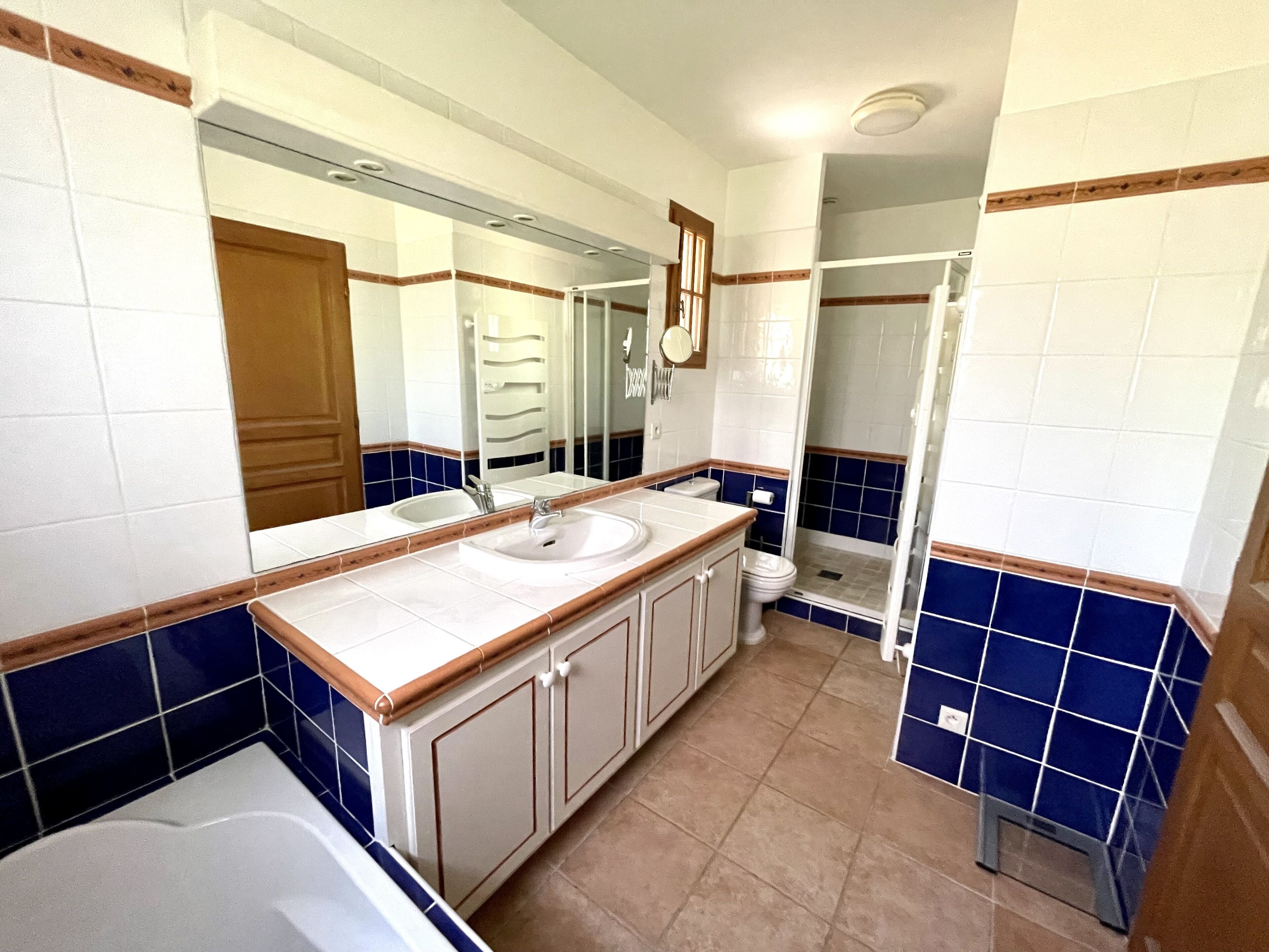 Ein Badezimmer mit Badewanne, zwei Waschbecken, Toilette und Dusche.
