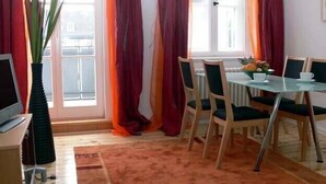 Ein Essbereich mit Tisch, Stühlen und einem fensterbepflanzten Fenster.