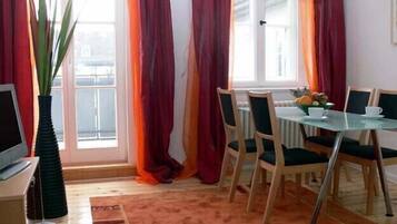 Ein Essbereich mit Tisch, Stühlen und einem fensterbepflanzten Fenster.