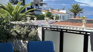 A table set outdoors with a mountain view, including a checkered tablecloth, plates with food, and a glass pitcher. - Beautiful house with a fascinating sea view - close to the beach (Tacoronte)
