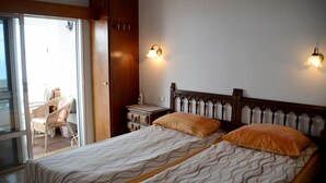 A hotel room with a bed, a nightstand, a chair, and a view of the outside. - Beautiful house with a fascinating sea view - close to the beach (Tacoronte)