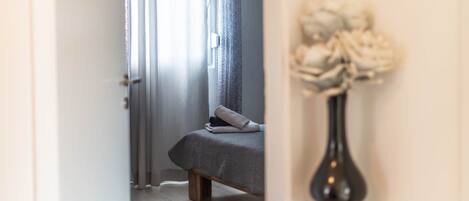 A bedroom with a bed, a dark rug, and a lamp.