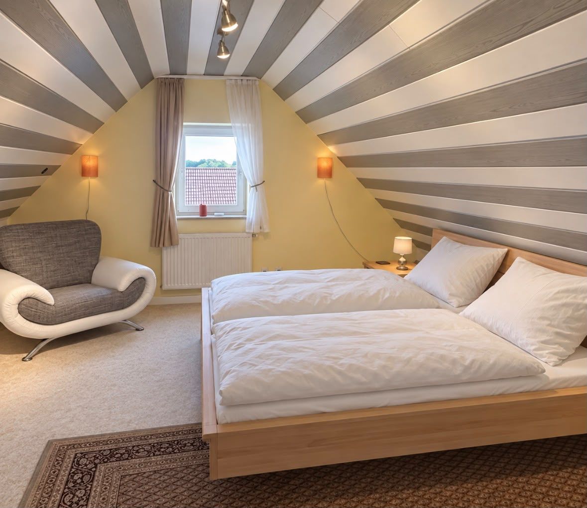 A bedroom with a bed, a chair, a window with curtains, and a radiator.