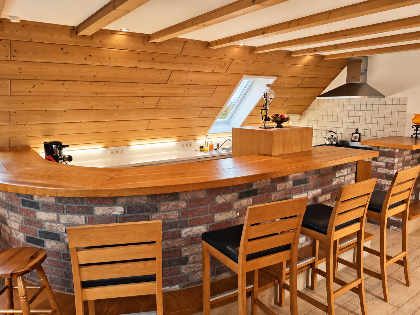 A kitchen with a wooden countertop, a brick backsplash, and a high ceiling with exposed beams.