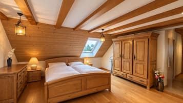 Ein Schlafzimmer mit Holzboden, einem Oberlicht, einem Bett, Nachttischen und einem Kleiderschrank.