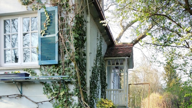 Una casa con encanto con un camino de jardín que lleva a una puerta de madera.