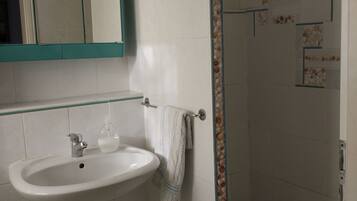 Ein Badezimmer mit Waschbecken, Spiegel und Dusche.