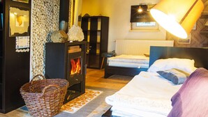 Una habitación acogedora con cama, chimenea, lámpara y techo de madera.
