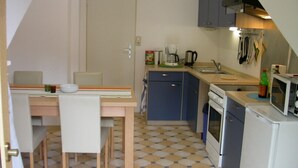 A compact kitchen with a dining area, featuring a sink, stove, microwave, and cabinets. - Frankfurt a. Experience M. - enjoy peace in the Taunus - children and dogs welcome (Schmitten)