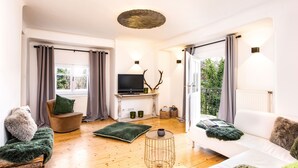 A modern living room with a sofa, a television, and a fireplace.