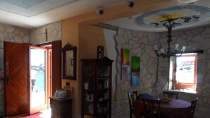 A room with a wooden door, a bookshelf, a dining table with chairs, and a window with a view. - unique historical STONE TOWER DIRECTLY BY THE SEA! carefully restored (Umag)