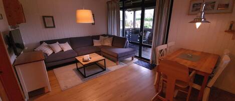 A cozy living room with a sofa, coffee table, and a dining area with a table and chairs.