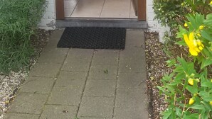 A wooden staircase leading to a white building entrance. - Bright vacation home for up to 6 people with fireplace, garden, parking and WiFi in De Haan (De Haan)