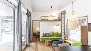 Ein modernes Interieur mit einem Etagenbett, einem Essbereich und Blick ins Freie.