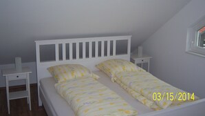 A single bed with a white headboard and two nightstands on either side.