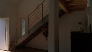 A staircase with a wooden handrail and metal balusters, leading to an upper floor.