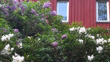Ein rotes Haus mit einem Ziegeldach und zwei Fenstern.