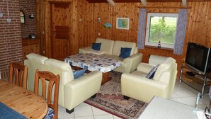 A cozy living room with a sofa set, a coffee table, and a TV.