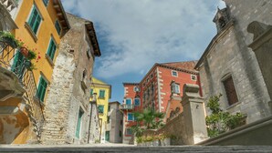 A narrow street with historic buildings, stone walls, and potted plants. - Villa Primela with breathtaking sea views and private pool (Labin)
