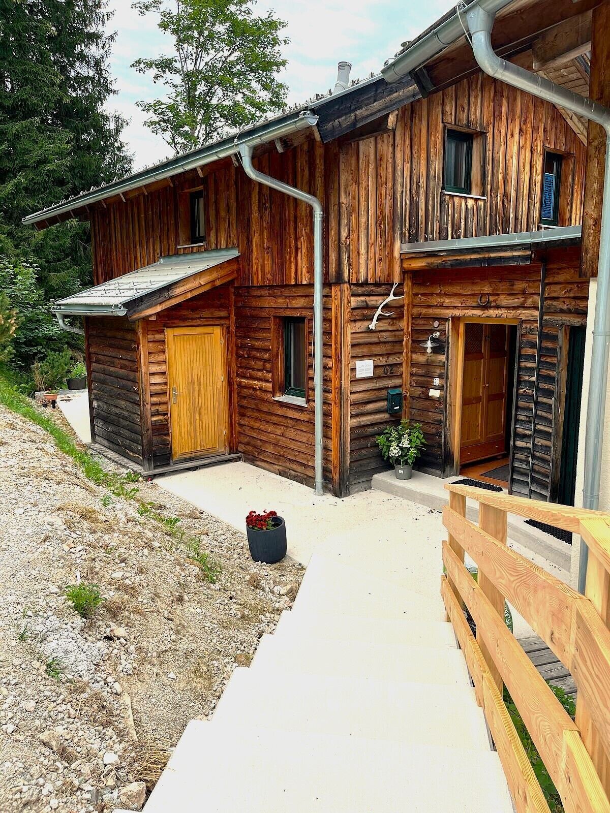 A wooden cabin with a covered porch, a front door, and a small window.
