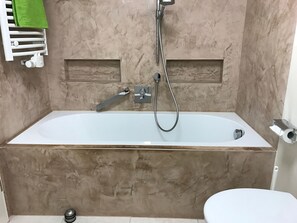 A bathroom with a bathtub, a shower, and a toilet. - Time out at Lake Constance - beautiful, well-kept 3-room apartment in Stockach-Wahlwies (Stockach)