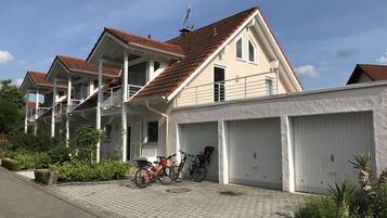 Ein Wohngebäude mit Garage, überdachter Veranda und einem Fahrrad davor.