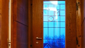 Eine Holztür mit Fensterglas, einem Türknauf und einem Klingel.