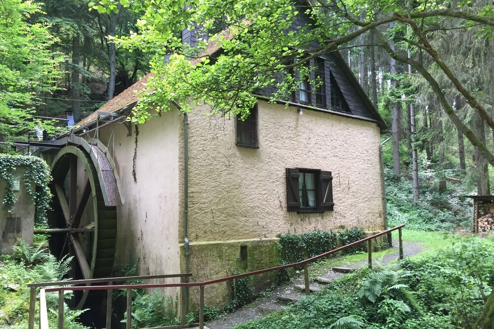 Old farm mill with a water wheel rebuilt as a vacation home
