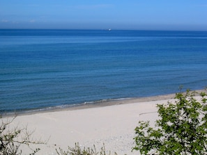 A beach with clear blue water and a sandy shore.