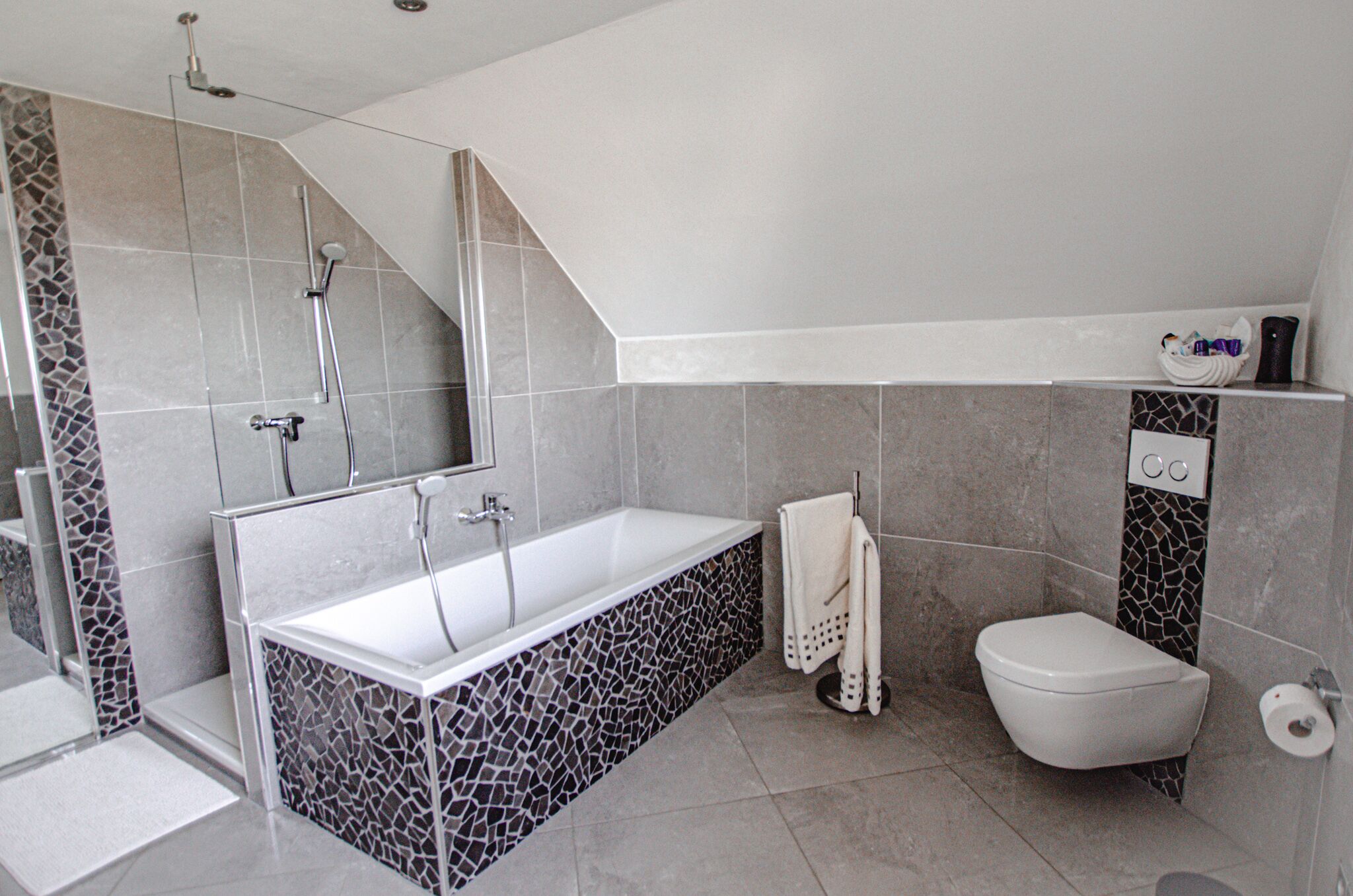 Un baño moderno con una bañera independiente, zona de ducha separada y un inodoro.