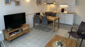 A modern apartment with a living room, dining area, and kitchen.