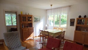 A dining area with a table, chairs, and a cabinet.