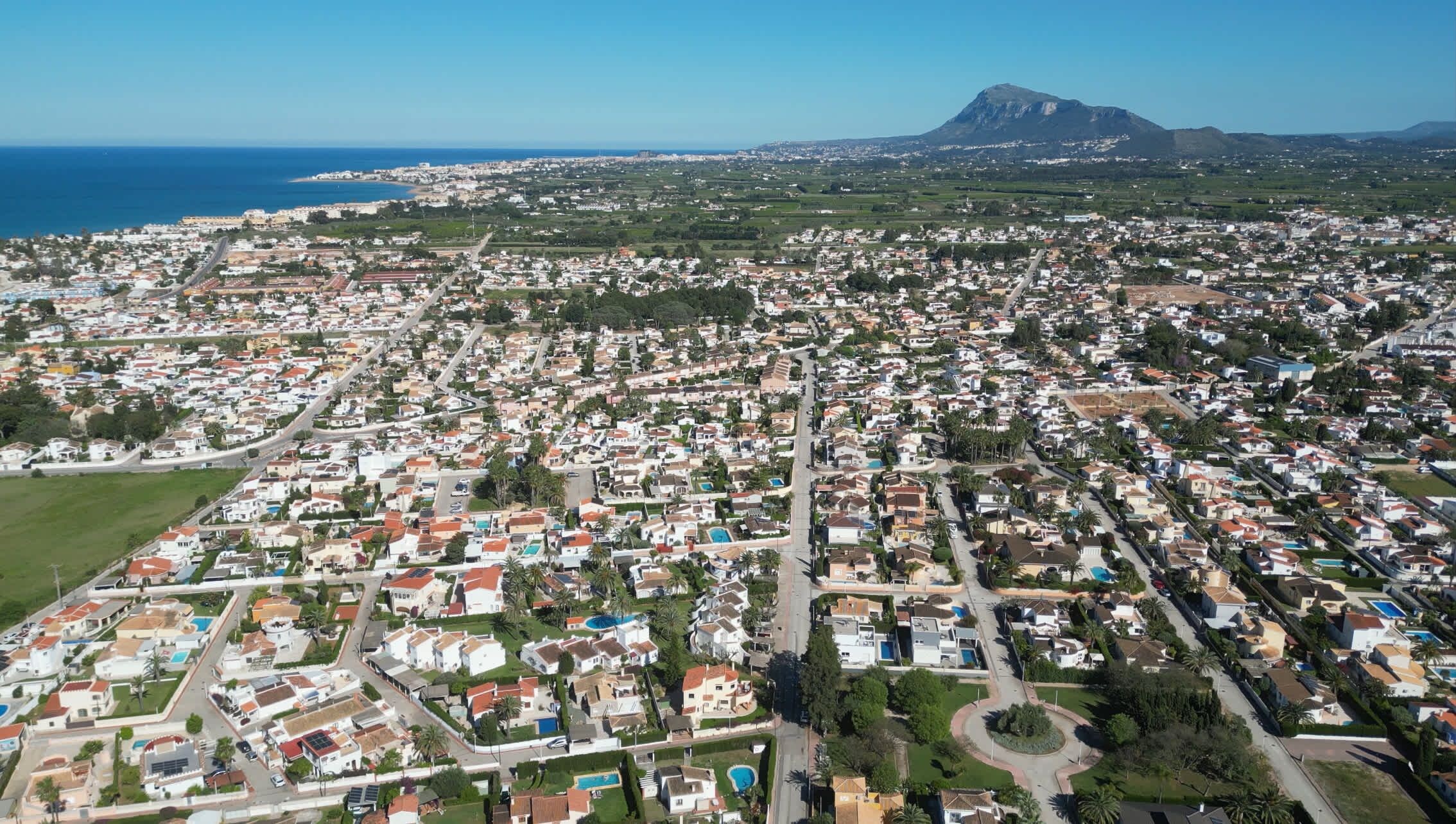 An aerial view of a densely populated residential area with a mountain in the background.